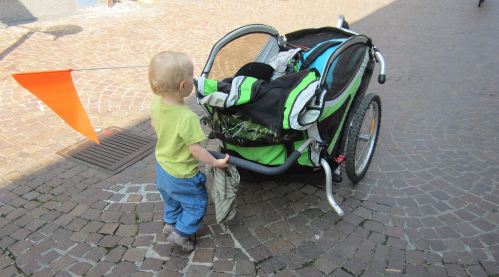 Kleines Kind schiebt seinen Fahhrradanhänger lieber selber