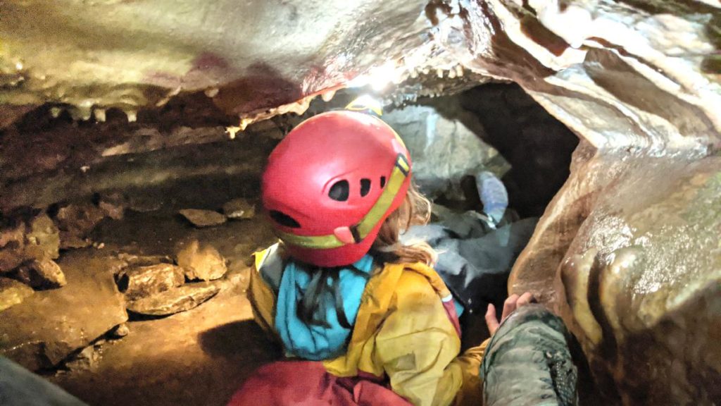 Kind in wilder Höhle, an einer Engstelle