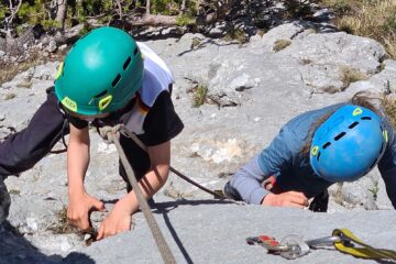 Kletternde Kinder mit bunten Kletterhelmen